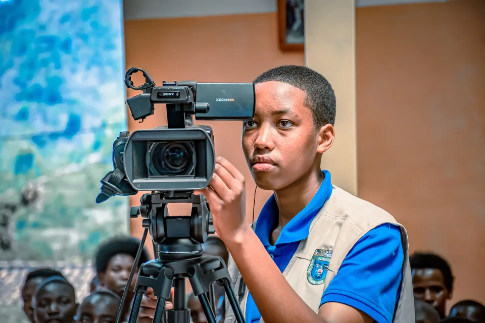 Cameraman operating a video camera at an event in Kigali